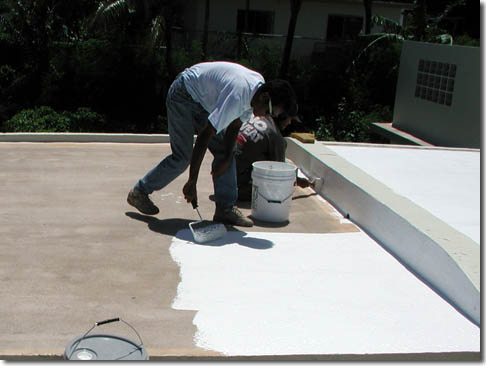 Roofer applying roof coating in Roland Park, MD